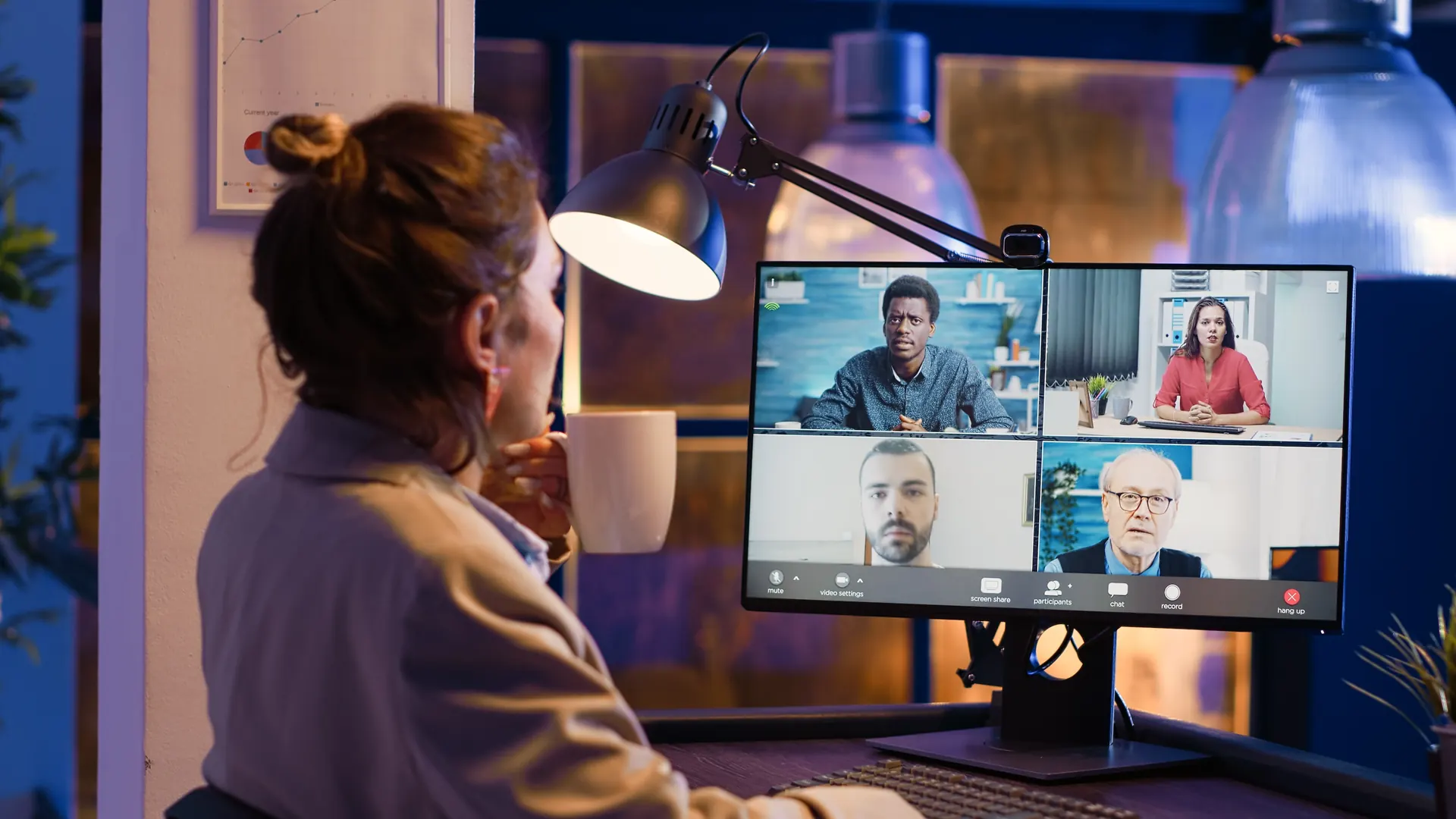 Ejecutiva en una videollamada con su equipo en pantalla